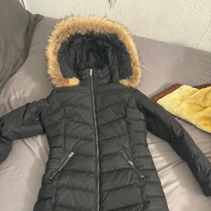 Svart Vinterjacka från Rockandblue - Säljer en svart vinterjacka från Rockandblue i mycket bra skick. Jackan har en mysig pälsfodrad huva och dragkedja framtill. Perfekt för kalla vinterdagar! 🖤