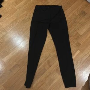 Svarta leggings från Stadium - Säljer ett par svarta leggings från Stadium i storlek M. De är i bra skick och perfekta för träning eller vardagsbruk. Materialet är stretchigt och bekvämt, vilket gör dem idealiska för en aktiv livsstil.