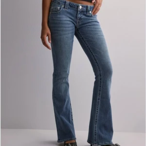 Blå bootcut jeans från True Religion - NYPRIS 1400kr! Säljer ett par snygga blå bootcut jeans från True Religion. De är lågmidjade och har en klassisk femficksdesign med märkets ikoniska broderi på bakfickorna. Perfekta för både vardag och fest! Aldrig använda och köpta från nelly butiken i stockholm. Säljer pga att jag köpte fel storlek och därför inte har mina egna bilder.