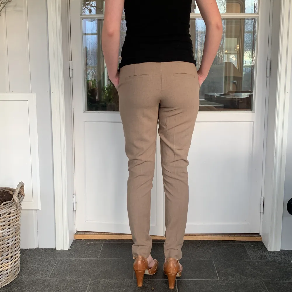 Säljer ett par snygga beige byxor från Selected Femme i storlek 34. De är midwaist och har en slim passform som ger en stilren look. Perfekta för både vardag och fest! Byxorna är i nytt skick med etikett kvar.. Jeans & Byxor.