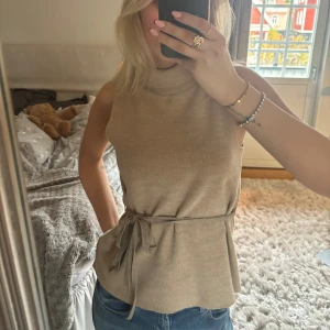 Zara topp med knytning - Så fin stickad topp från zara med polokrage och knytning i midjan🤎 använd en gång