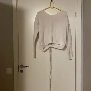 Vit stickad tröja - Jättefin stickad tröja från nelly med snörning därbak. Fint skick!