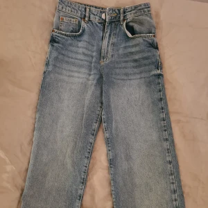 Blå jeans - Säljer ett par snygga blå jeans i 90-talsstil med rak passform. De är högmidjade och har en klassisk femficksdesign. Perfekta för en avslappnad look eller att klä upp med en snygg topp. Jeansen är nya och oanvända. 