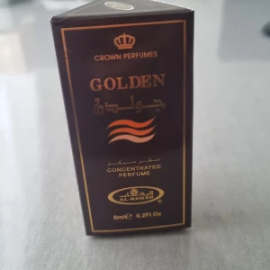 Golden Concentrated Perfume från Crown Perfumes - Säljer en elegant och lyxig Golden Concentrated Perfume från Crown Perfumes. Förpackningen är mörkbrun med gyllene detaljer och rymmer 6 ml av denna exklusiva doft. Perfekt för den som vill ha en långvarig och intensiv doftupplevelse. Passar både till vardags och speciella tillfällen.