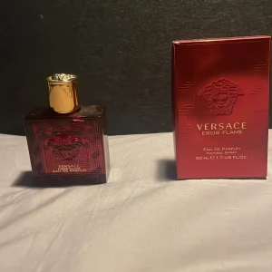 Versace Eros Flame Eau de Parfum - Säljer en Versace Eros Flame Eau de Parfum, 50 ml. Flaskan är fyrkantig och röd med ett guldigt lock. Doften är intensiv och maskulin, perfekt för speciella tillfällen. Kommer i en snygg röd kartong med Versace-loggan. Perfekt present eller för att unna dig själv något lyxigt! 🌟