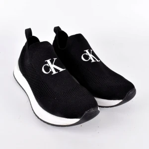 Svarta sneakers från Calvin Klein - Snygga svarta sneakers från Calvin Klein i stickat mönster med vit sula. De har en stilren design med CK-logga på ovansidan och Calvin Klein Jeans-text på sulan. Perfekta för en casual look och superbekväma att bära hela dagen.