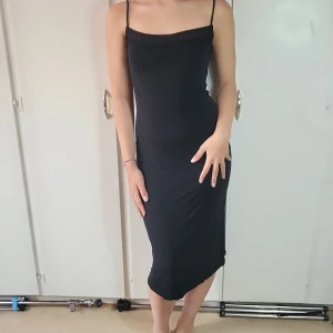 Klänning - Stilig, svart KOOKAÏ-klänning med meshkant. Faller fint från kroppen. Nyskick, använd vid två tillfällen. 