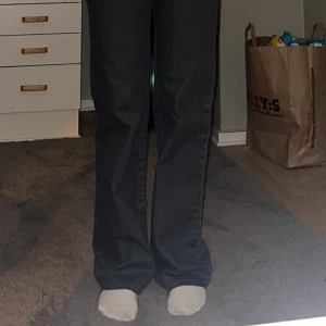 Grå jeans med dekorativa detaljer - Säljer ett par snygga grå jeans i bra skick. De har en normal passform och är högmidjade. På bakfickan finns dekorativa detaljer. 