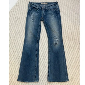 Bootcut jeans från Big Star - Säljer ett par snygga lowaist bootcut jeans från Big Star. De har en cool slitning på framsidan och snygga detaljer på bakfickorna. Midjemåttet:ca 78cm Innerbenslängden: ca 77cm