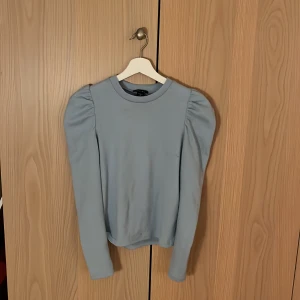 Blus  - Bra skick. Fin blå färg med axel volang.