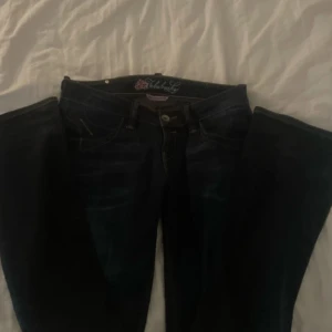 Mörkblå g rise jeans från Fornarina - Säljer ett par snygga mörkblå jeans från Fornarina med 'Fabulous Legs' design. De har en klassisk femficksmodell och knappar med märkets logga. Perfekta för både vardag och fest!