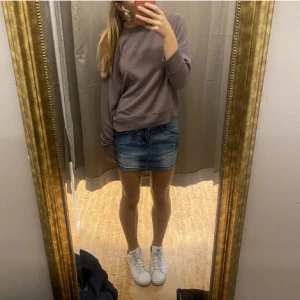 Blå jeanskjol - Säljer en snygg blå jeanskjol i kort modell. Perfekt för sommardagar eller en avslappnad utekväll. Kjolen har en klassisk design med fickor och en bekväm passform. Matcha med sneakers eller sandaler för en cool look!