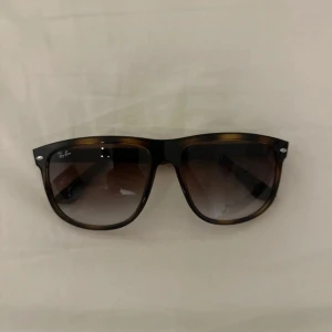 Boyfriend från Ray-Ban - Snygga solglasögon från Ray-Ban i den populära boyfriend modellen.  De har en brun sköldpaddsmönstrad båge och mörka tonade glas. Perfekta för både vardag och fest! Modellen är RB 4147 och de är i mycket bra skick.