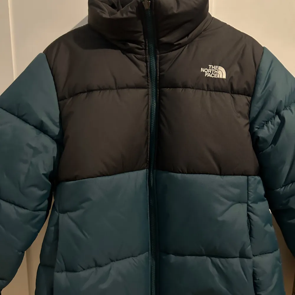 Säljer en snygg och varm pufferjacka från The North Face i grön och svart. Perfekt för kalla vinterdagar. Jackan har en dragkedja framtill och är i mycket bra skick. Köpt förra vintern. Passar perfekt för både vardag och utomhusaktiviteter. Storlek M.. Jackor.