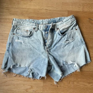 Ljusa jeansshorts från H&M - Säljer ett par ljusa jeansshorts från H&M i boyfriend-stil. De har en sliten look med fransiga kanter och revor för en avslappnad vibe. Köpt second hand! 🩵