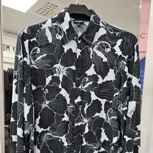 Svartvit mönstrad skjorta från Just Cavalli - Säljer en snygg svartvit skjorta från Just Cavalli med ett coolt blommönster. Skjortan har långa ärmar och knappar framtill. Perfekt för både fest och vardag! Tillverkad i Rumänien och i mycket bra skick. Passar perfekt för dig som vill sticka ut med stil. 🌟Skjortan har en liten aning blå avfärgning från tvätten. Annars I fin skick!