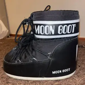 Säljer ett par svarta Moon Boots i syntetmaterial. De har en cool och unik design med snörning och en vit sula. Perfekta för vinterns kalla dagar och håller fötterna varma och torra. Passar både till vardags och på skidresan! Kostar 2 tusen nya använda 2 gånger 