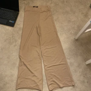 Beige byxor från Bik Bok - Säljer ett par snygga beige byxor från Bik Bok i storlek S. De har en loose passform och är perfekta för både vardag och fest. Byxorna är tillverkade i ett mjukt material som känns skönt mot huden. Perfekta för höst och vår!