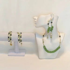 Grönt smyckeset med halsband, armband och örhängen - Snyggt smyckeset i grönt med ett halsband, två armband och ett par örhängen. Halsbandet har gröna pärlor och guldfärgade detaljer. Armbanden matchar med gröna och svarta pärlor samt vita detaljer. Perfekt för att piffa upp en outfit! Ett par örhängen och ett par armband plus en halsband handgjorda mycket mycket fint nytt oanvänd 