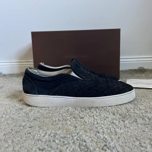 Bottega Veneta slip ons - Ett par feta Bottega Veneta slip ons. Storlek 41. Dem är i bra skick (förutom en att dem är slitna i hälen på insidan på båda), be om bild privat. Box, kvitto & dustbag medföljer. Hör av dug vid frågor eller funderingar.