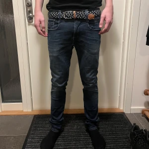 Mörkblå jeans från Replay - Säljer ett par snygga mörkblå jeans från Replay, modell Anbass. De har en slim passform och är i bra skicka bara att lite av tyget typ gått upp som ni kan se på bild 5. Modellen är 180 och väger 63.