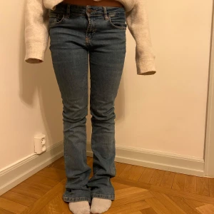 Blå bootcut jeans - Säljer ett par snygga blå bootcut jeans i bra skick. De är lågmidjade och har en klassisk femficksdesign. Perfekta för både vardag och fest! Passar till allt från sneakers till klackar.