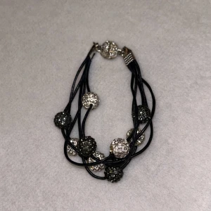 Svart armband med glittriga pärlor - Snyggt svart armband med flera glittriga pärlor i silver och svart. Ej justerbart. 