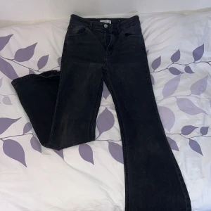 Svarta jeans från Pull&Bear - Säljer ett par snygga utsvängda svarta jeans från Pull&Bear i storlek 38/M. De sitter bra mot kroppen och är i bra skick. Perfekta för både vardag och fest! 🖤