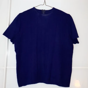 Mörkblå topp  - Snygg mörkblå topp i ett mjukt och bekvämt material. Perfekt för både vardag och fest. Toppen har en enkel design med korta ärmar och rund hals. Ett måste i garderoben för den stilmedvetna!