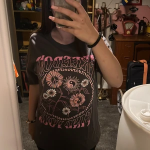 Svart t-shirt med tryck - Säljer en svart t-shirt med coolt tryck i rosa och vitt. T-shirten är i bra skick och har en normal passform. 