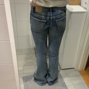 Blå Weekday jeans - Säljer ett par snygga blå jeans från Weekday i modellen Flame Low Flared. Nästan aldrig använda så mycket bra skick. Pris kan även diskuteras🤍