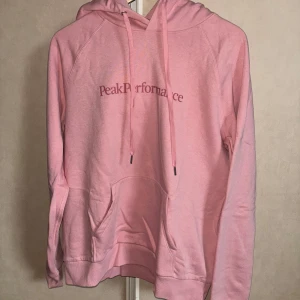 Rosa hoodie från Peak Performance - Säljer en superfin rosa hoodie från Peak Performance i storlek XL. Den är i bra skick och perfekt för både höst och vår. Hoodien har en klassisk design med känguruficka och justerbar huva. Perfekt för en avslappnad stil! 💖