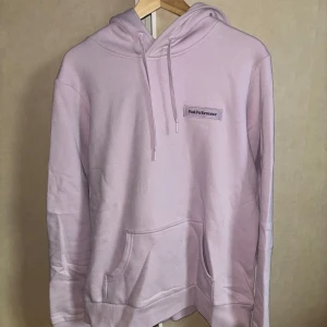 Ljuslila hoodie från Peak Performance - Säljer en supermysig ljuslila hoodie från Peak Performance. Den har en klassisk design med känguruficka och justerbar huva. Perfekt för kyliga dagar eller mysiga hemmakvällar. Märket är broderat på bröstet för en stilren look. Passar perfekt till både vardag och avslappnade tillfällen. 💜