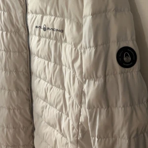 Sail Racing Jacka  - Jacka Vit Sail Racing  , urtvättad men fin.  Vänster ficka går inte att stänga. 