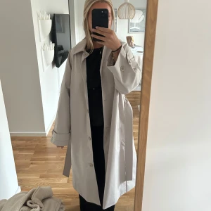 Trenchcoat  - Beige trenchcoat som ör helt oanvänd, lappen kvar!!