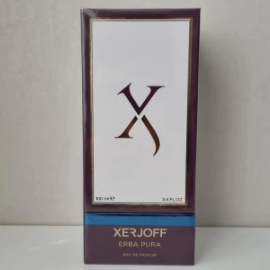 Xerjoff Erba Pura Eau de Parfum - Säljer den lyxiga parfym från Xerjoff, Erba Pura. Den kommer i en elegant lila förpackning med guldiga detaljer och en stilren design. Flaskan innehåller 100 ml av denna exklusiva doft, perfekt för den som vill ha något unikt och sofistikerat.