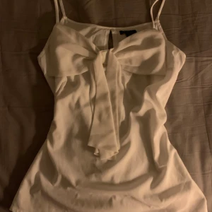 Vit topp med rosett  - Köpt här på plick men kände att den inte var min stil, passar s-m. Pris kan diskuteras!