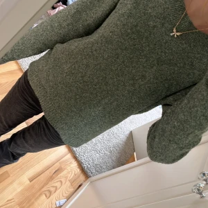 Grön stickad tröja - Säljer en supermysig grön stickad tröja som är perfekt för kyliga dagar. Den har en enkel design med långa ärmar och en normal passform. Perfekt för både höst och vinter!