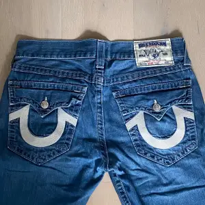 Snygga true religion i bootcut fit i jätte bra skick. De är lite missfärgade i fram på låren som syns på bilden. Säljer eftersom att de är för korta för mig. Hör av er ifall ni vill ha måtten!