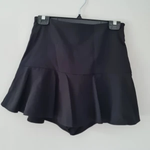 Svart kjol - Svart kjol från Zara med inbyggda shorts.