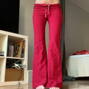 Röda lågmidjade byxor - Röda byxor med låg midja Innerbenslängd: 77-78cm Midjemått: 37cm (mätt rakt över + med justerbart band)