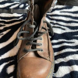 Dr Martens 8A18 Ankle Boots 40.5 - Till salu: Dr. Martens 8A18 Ankle Boots Brun, storlek 40.5  Jag säljer mina Dr. Martens 8A18 i utmärkt skick. De är bruna i färgen och i storlek 40,5 som passar till storlek 40 och 41. Väldigt lite använda, de är nästan nya! Jag säljer dem för att de