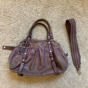 Marc Jacobs väska  - Snygg vintage Marc Jacobs väska!! En större modell, axelband tillkommer. Lite sliten men inga skador som påverkar användningen
