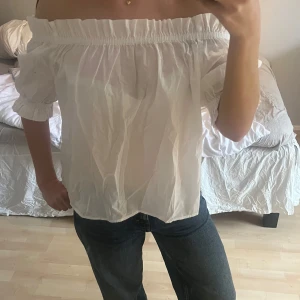 Vit offshoulder blus från H&M - Säljer en söt vit offshoulder blus från H&M. Blusen har elastiska kanter vid axlarna💕