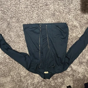 Mörkblå jacka med dragkedja från East West, Brothers - Mörkblå jacka med dragkedja från East West, Brothers. Jackan har en stilren design med långa ärmar och är perfekt för en casual look. Den är tillverkad i ett lätt material som gör den bekväm att bära. Nypris: 799 kr