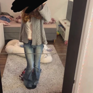 Grå stickad kofta från TRF - Säljer en mysig grå stickad kofta från TRF med flätmönster och huva. Koftan har långa ärmar och knytband framtill. Perfekt för kyliga dagar!