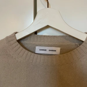 Beige stickad tröja från Samsøe Samsøe - Säljer en beige stickad tröja från Samsøe Samsøe i storlek M, gjord av ull. Bra skick! 