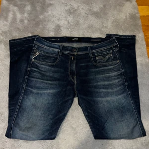 Mörkblå jeans från Replay - Snygga mörkblå jeans från Replay med klassisk femficksdesign. Det är modellen replay anbass hyperflex. De har en slim passform och är perfekta för en avslappnad stil. Märkeslogga på bakfickan som ger en extra touch. Bra skick endast använda ett få tal gånger. Skick 9/10. Priset är 500kr orkar inte att folk skickar prisförslag hela tiden då de nästan redan är gratis. Jag går tillräckligt mycket back. Annars köp de nya 1700kr