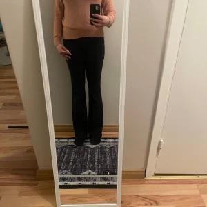 Rosa stickad tröja - Säljer en snygg rosa stickad tröja med v-ringning. Tröjan har långa ärmar och en åtsittande passform som framhäver figuren. Perfekt för kyligare dagar.