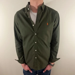 Olivgrön Ralph Lauren skjorta - Nu säljer vi ännu en fet polo skjorta som passar till alla tillställningar och skjortan är i mycket bra skick! Du ska kunna uttrycka stil utan att det kostar för mycket!🕺🍾💼🤩  Storlek👔: M Nypris💰:  ca 1499 kr